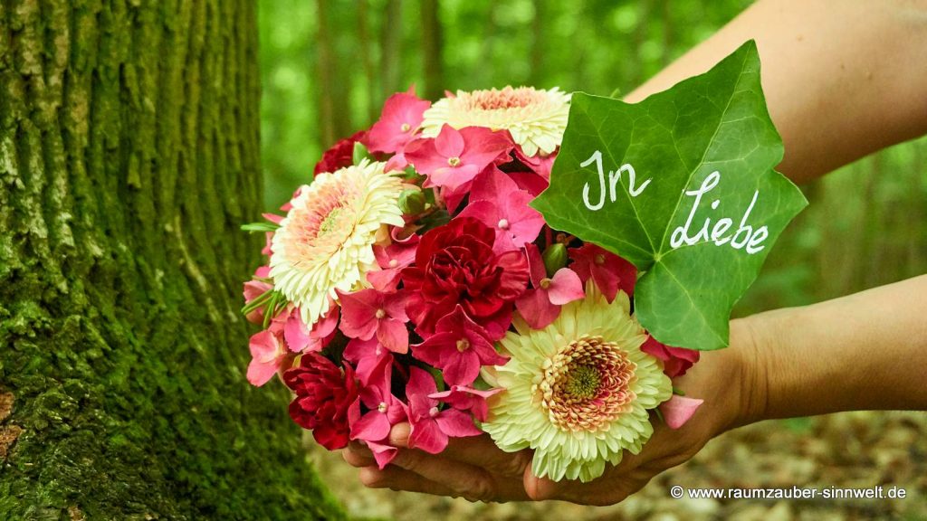 Blütenkugel für den Friedwald aus Hortensien und Gerbera mit beschriebenem Blatt.