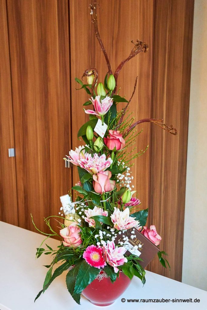 Frischblumengesteck aus Rosen, Lilien und Gerbera dekoriert mit SCHELL-Schokolade und Likör "Scharfes Gelb"