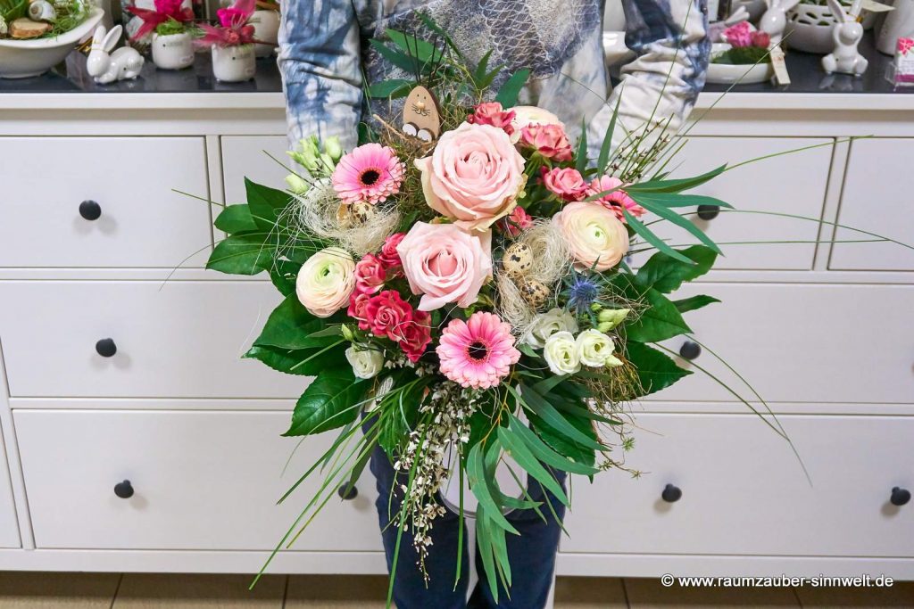 Rundstrauß aus Rosen, Ranunkeln Eustoma, Ginster und Gerbera österlich dekoriert