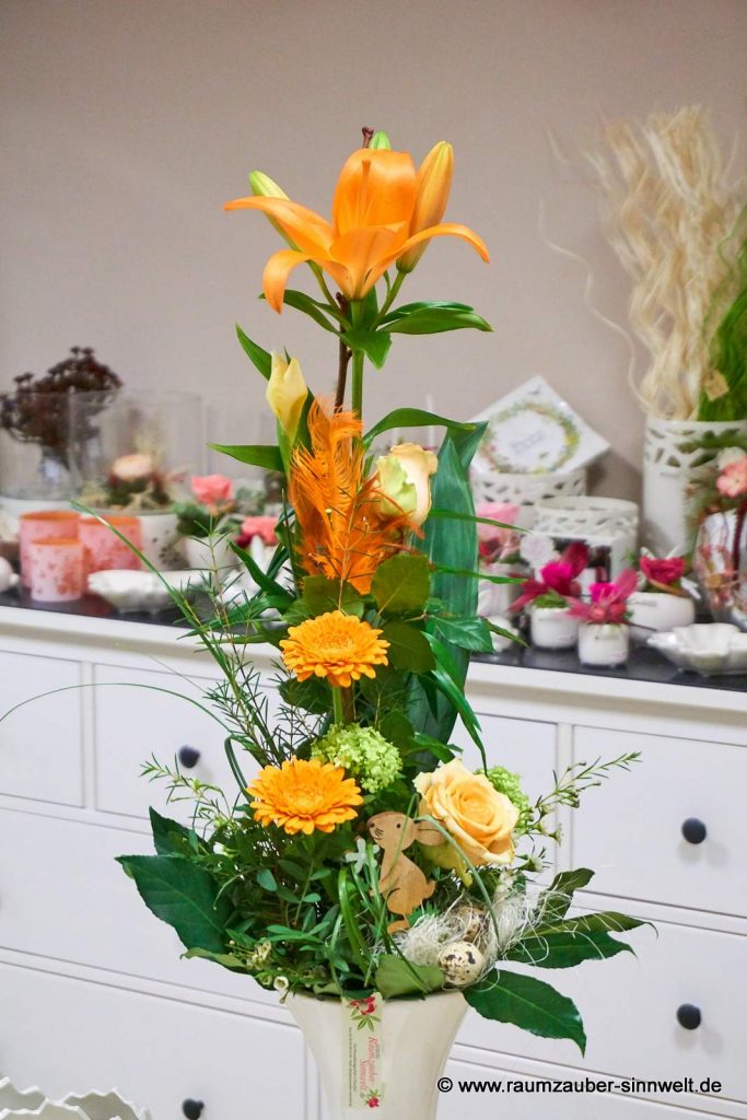 Versetzt gebundener Strauß aus Lilien, Rosen, Schneeball und Gerbera österlich dekoriert