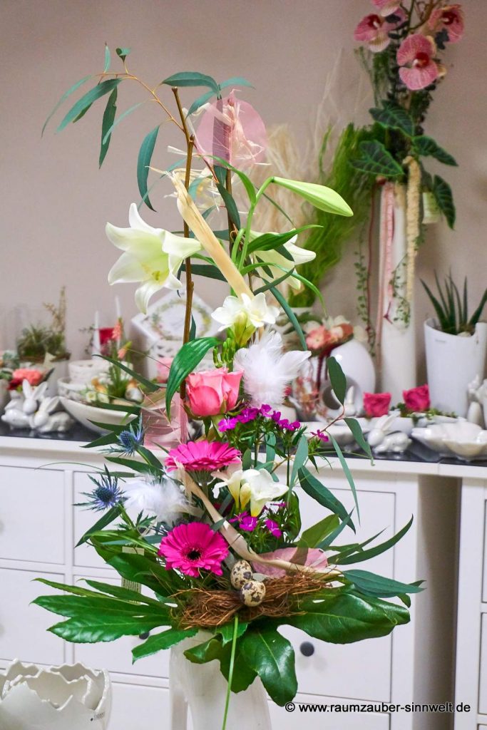 Versetzt gebundener Strauß aus Lilien, Rosen, Freesien und Gerbera österlich dekoriert