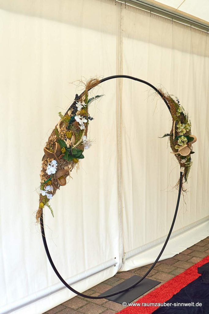Hochzeitsbogen mit handgefertigten Seidenblumengestecken als Eingangsdekoration