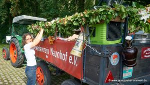 Wir schmücken den Festwagen mit farbenfroh gemischten Blumengirlanden