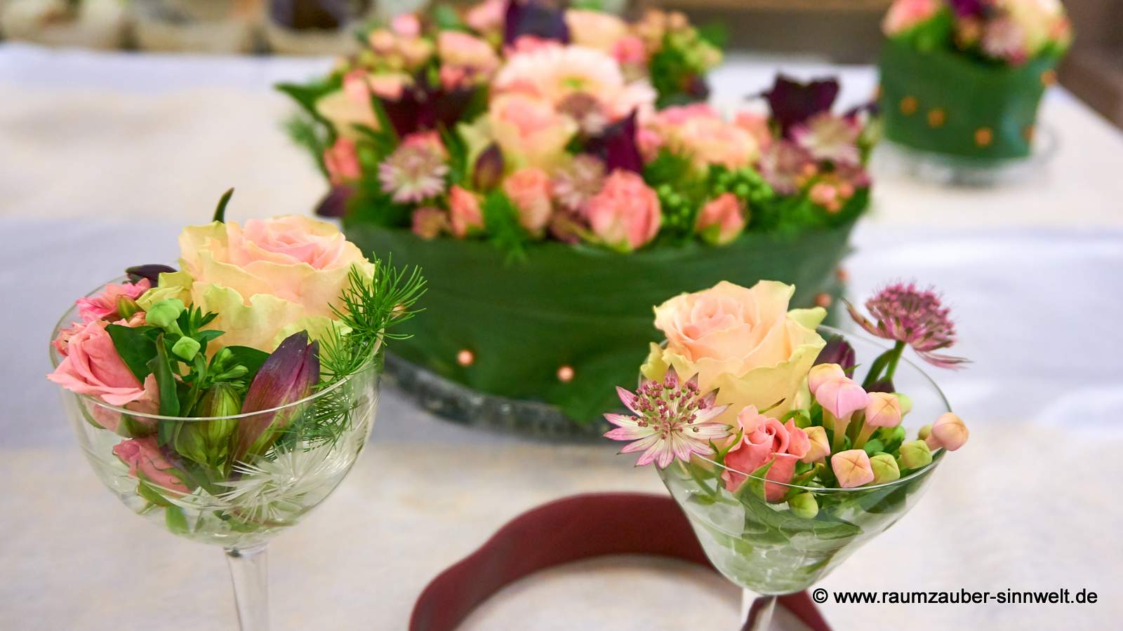 Blumentorte und gefüllte Gläser als Tischdekoration aus Rosen, Astrantien, Alstromerien und Gerbera