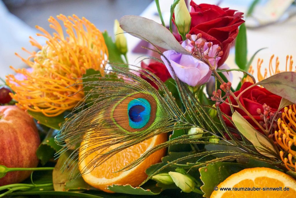 Tischdekoration aus exotischen Blüten und Früchten