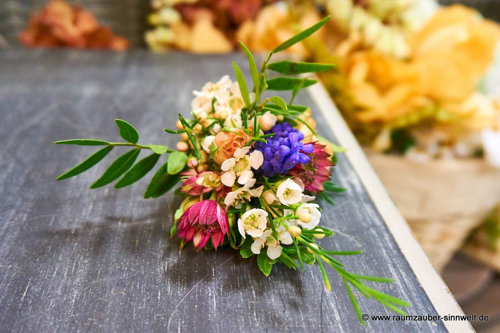 Anstecker aus Astrantien, Polyrosen, Margariten, Freesien, Traubenhyazinthen und Wachsblümchen