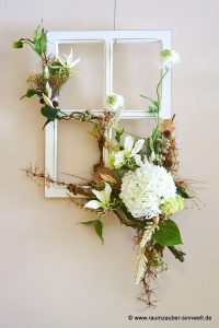Deko-Fenster handdekoriert mit Seidenblumen und Naturmaterialien als florales Bild