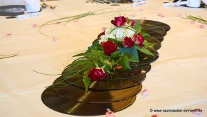 Tischdekoration aus Rosen und Hortensien auf Schallplatten