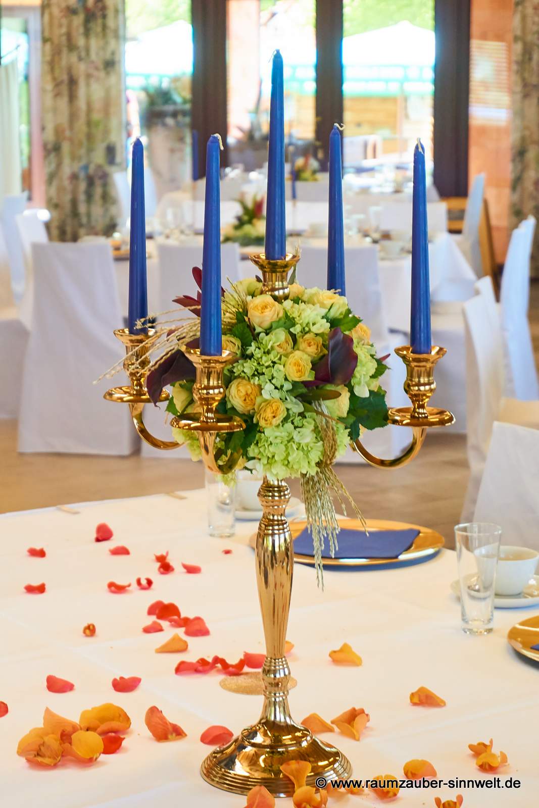 Tischdekoration aus Hortensie, Rosen, Calla und Gräsern auf Kerzenleuchter