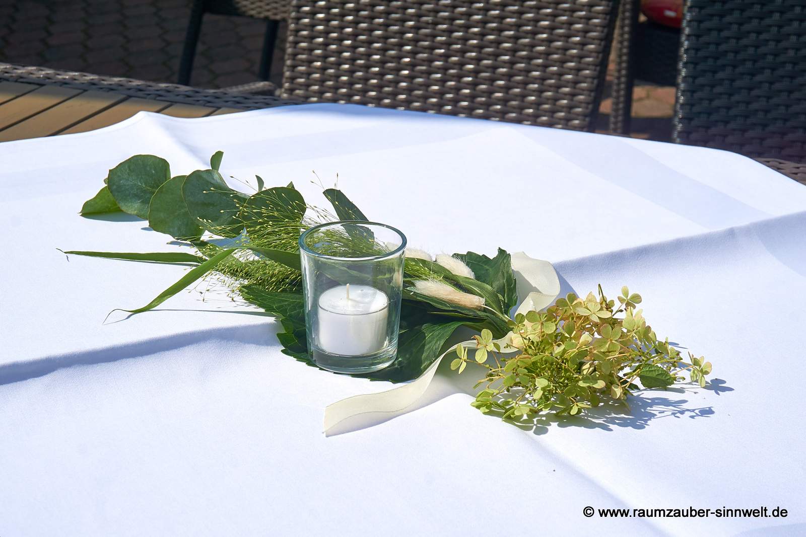 Tischdekoration aus Hortensie, Eukalyptus und Gräsern mit Teelicht