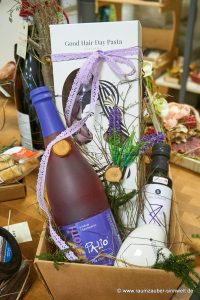 Dekorierter Präsentkorb mit Frucht- und Gewürz- Olivenöl aus Kreta von Deligreece, prickelndem Secco und Nudeln "Good Hair Day Pasta" von Greenomic.