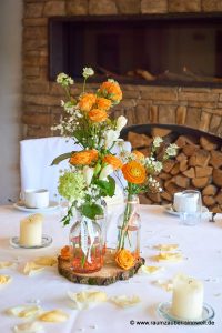 Tischdekoration aus Rosen, Freesien, Astrantien und Schleierkraut auf Baumscheibe