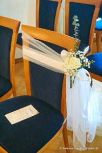 Stuhldekoration für das Standesamt aus Rosen und Gräsern