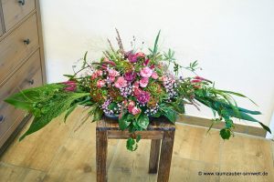 Tischdekoration aus Hortensien, Rosen, Veronika, Gräsern und Schleierkraut