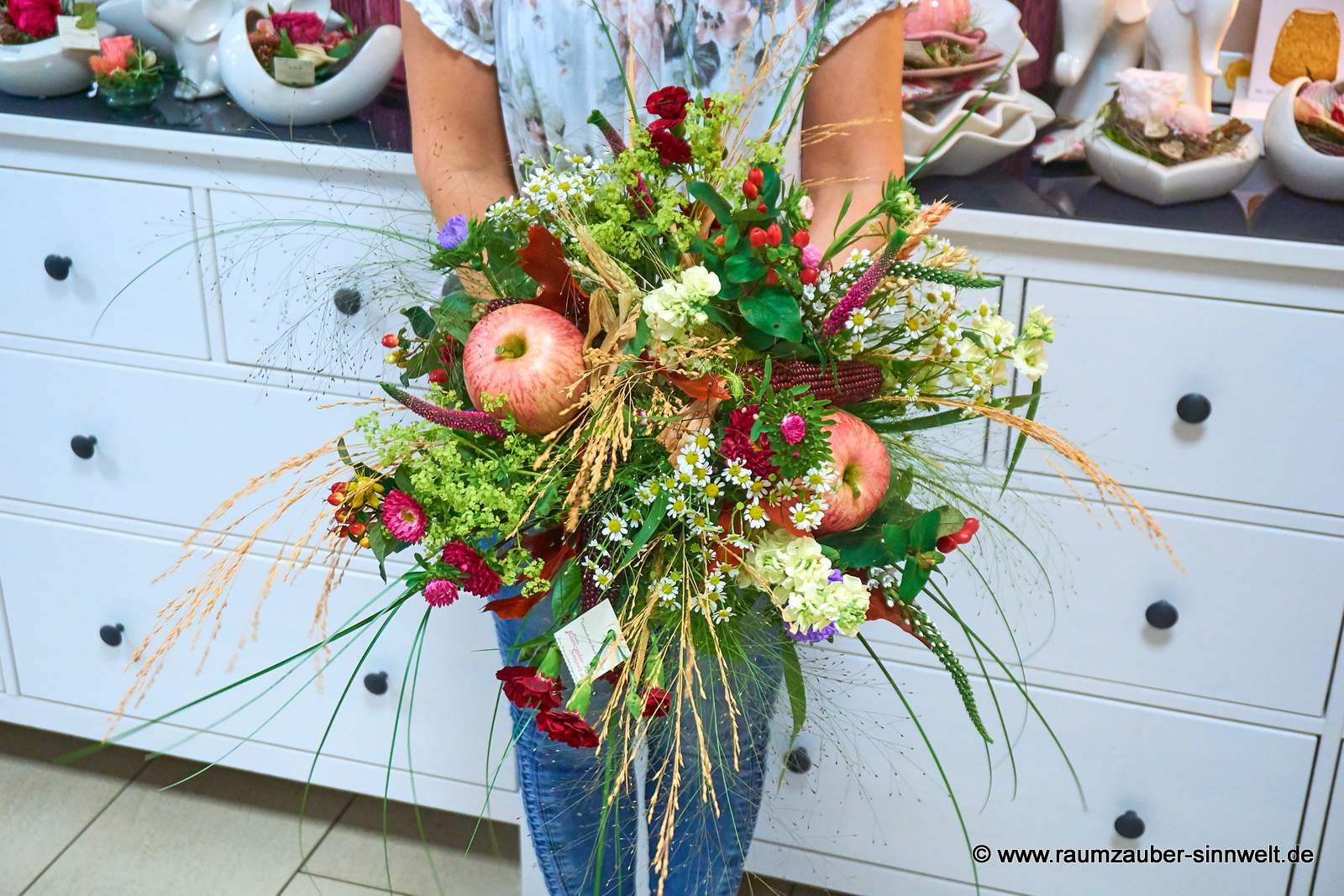Herbstlicher Rundstrauß aus Äpfeln, Mais, Kamille, Astern, Veronika und Gräsern.