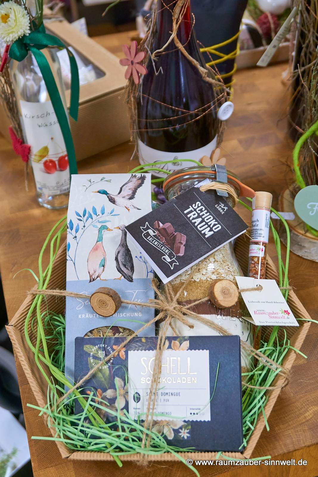 Präsentkorb mit Backmischung von deutschem Obst- und Gemüsehof, Gewürzröhrchen, Kräutertee vom Grätzverlag und Schokolade aus der SCHELL-Schokoladenmanufaktur.