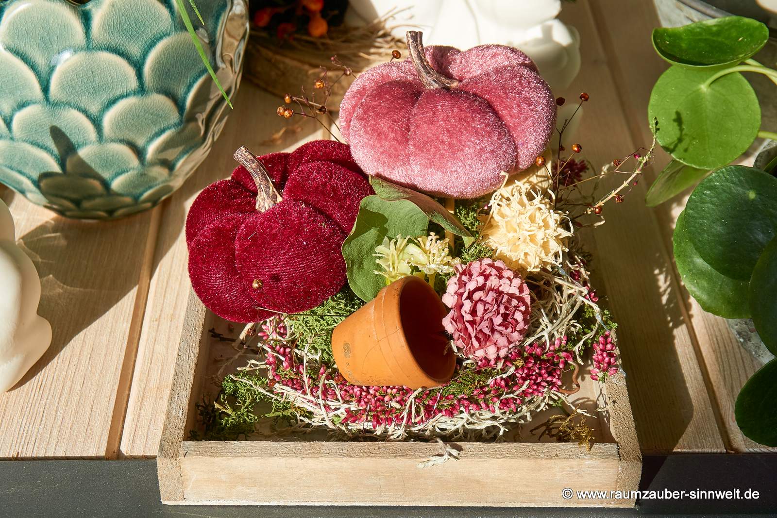 Herbstgesteck mit Samtkürbissen auf Holztablett