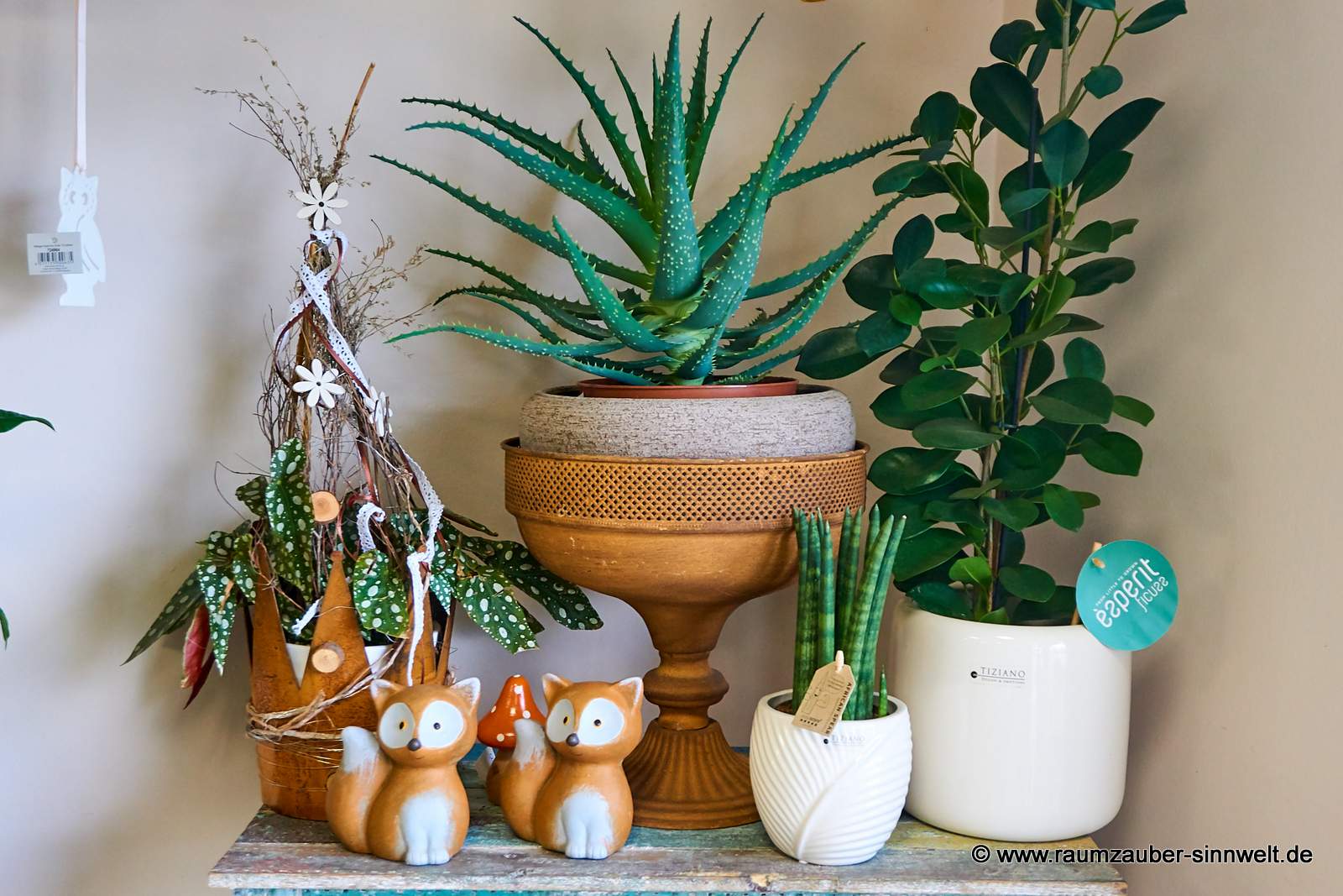 Deko-Fuchs mit Grünpflanzen in Rost- und Keramikgefäßen