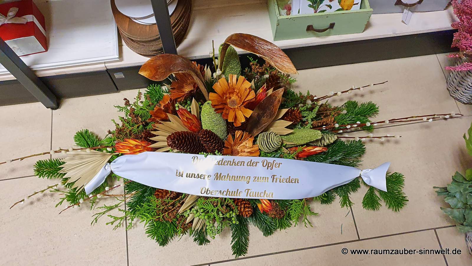 Gesteck zum Gedenken mit naturfarbenen Exoten und Schleife