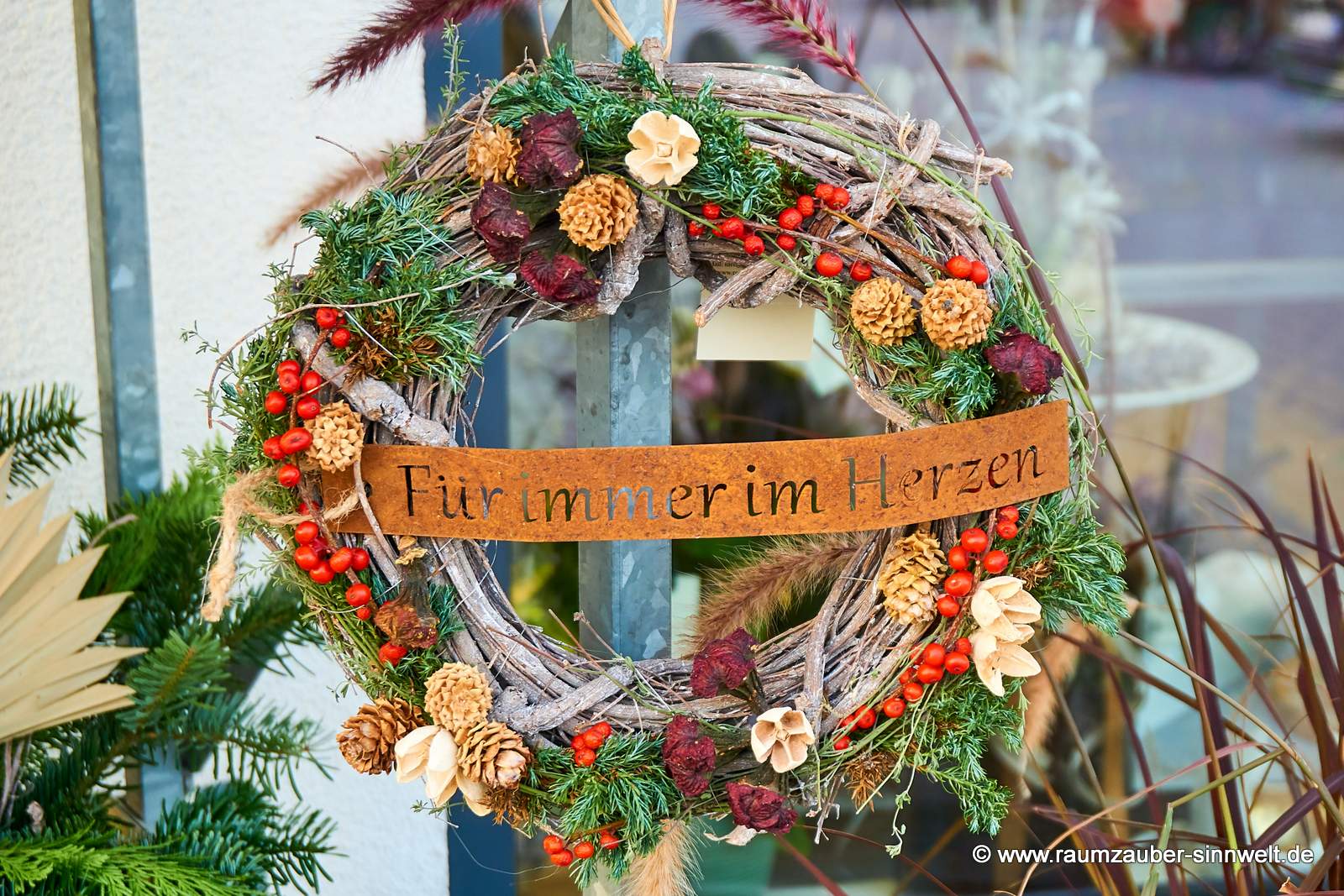 Trauerkranz zum Gedenken mit farbigen Exoten und Rostschild