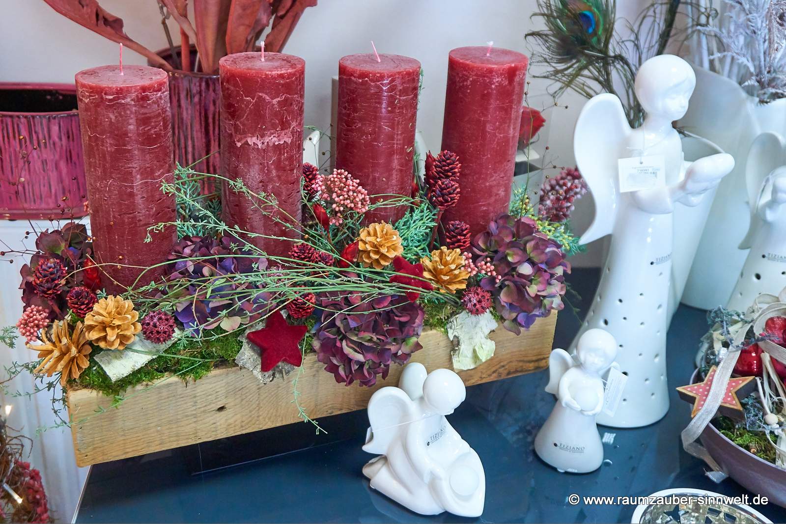 Handgefertigtes Adventsgesteck aus Naturmaterialien mit vier Kerzen und Weihnachtsdekoration