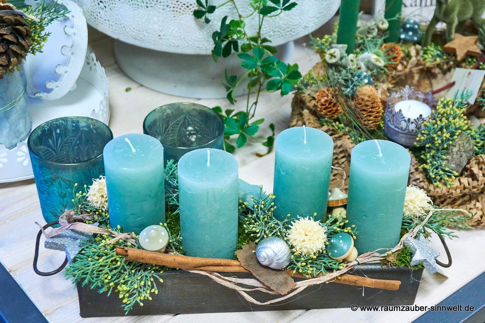 Handgefertigtes Adventsgesteck aus Naturmaterialien mit vier Kerzen und Weihnachtsdekoration