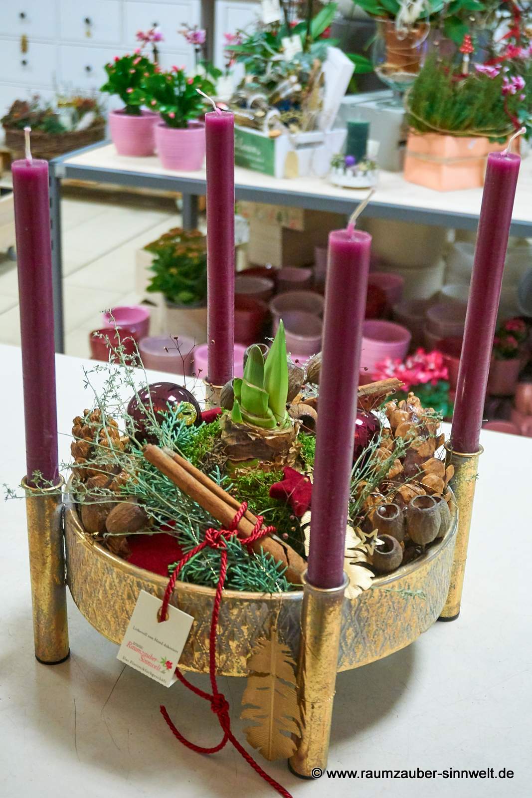 Handgefertigtes Adventsgesteck aus Naturmaterialien und Kugeln mit vier Stabkerzen, Amaryllispflanze und Weihnachtsdekoration