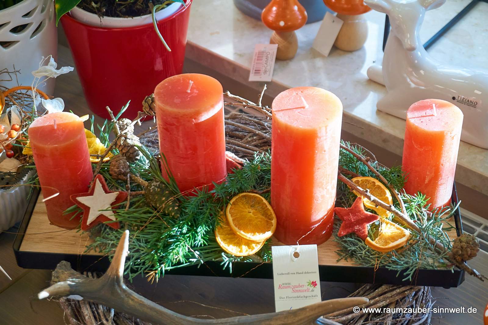 Handgefertigtes Adventsgesteck aus Naturmaterialien mit vier Kerzen und Weihnachtsdekoration