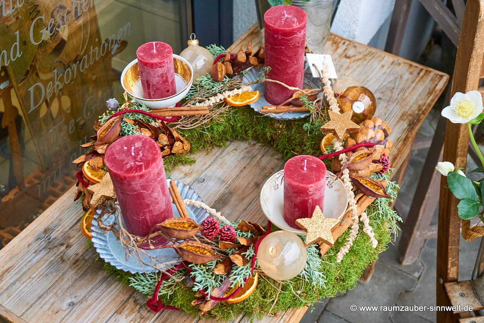 Handgefertigter klassischer Adventskranz aus Naturmaterialien und Kugeln mit vier Kerzen und Weihnachtsdekoration