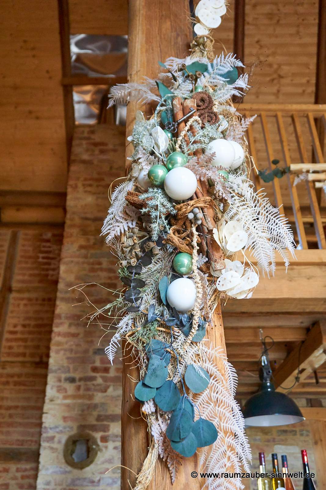 Winterliche Wanddekoration aus Naturmaterialien und Kugeln.