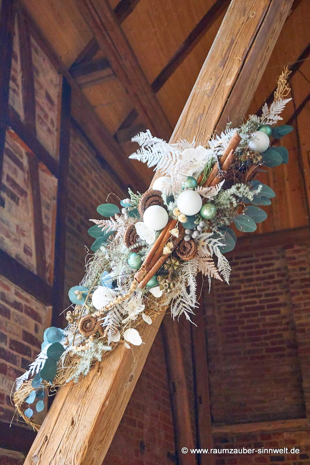 Winterliche Wanddekoration aus Naturmaterialien und Kugeln.