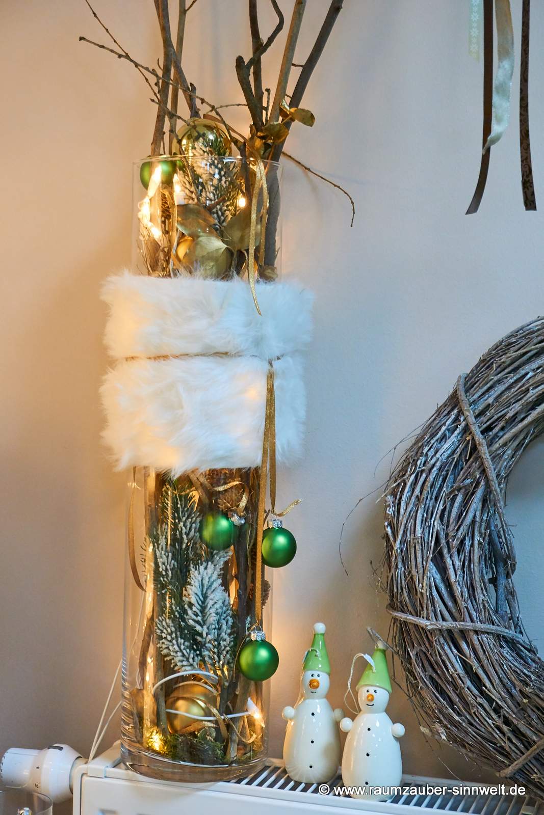 Weihnachtsdekoration aus Naturmaterialien und Kugeln im Glas mit LED-Lichterkette und Deko-Schneemänner
