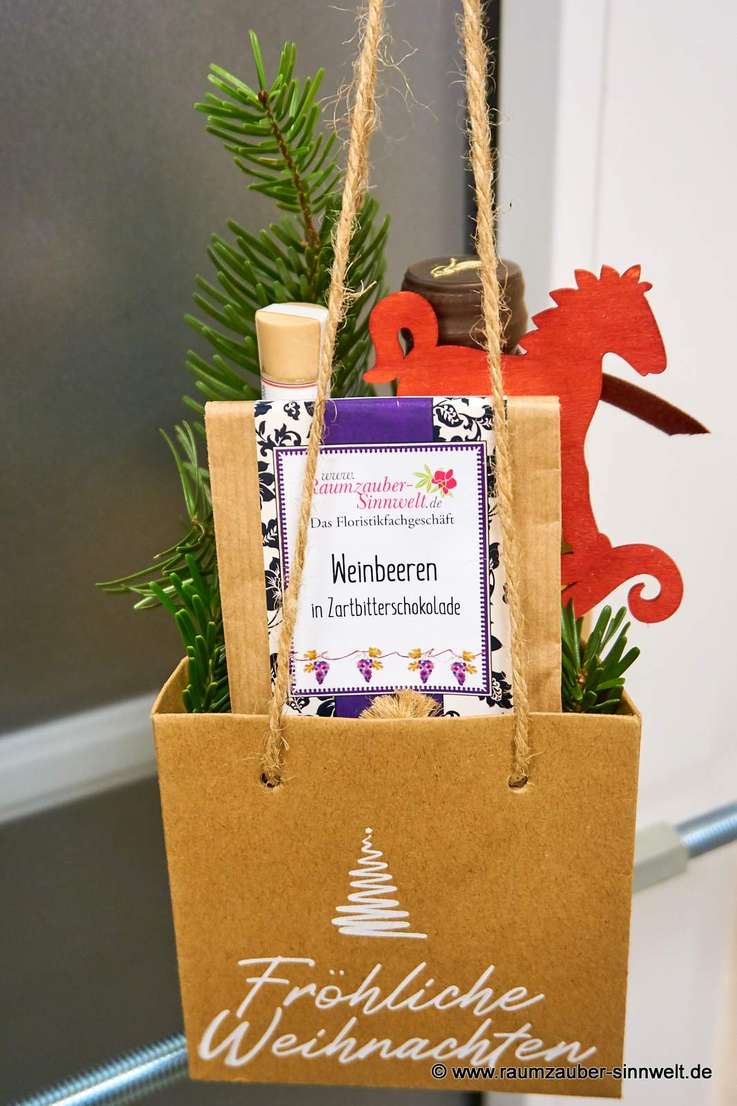 Präsent mit Likör "scharfesGelb", Gewürzröhrchen und Schokofrüchten weihnachtlich dekoriert