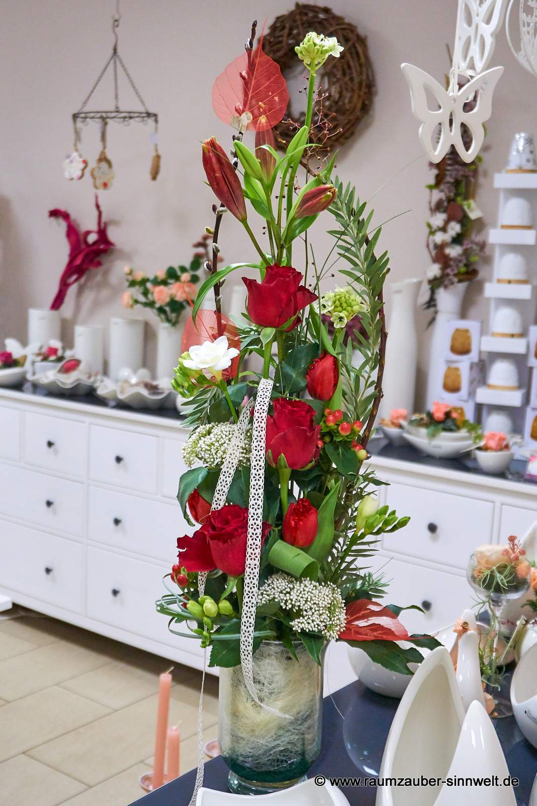 Blumengesteck aus roten Rosen, Lilien, Freesien und Trachelium