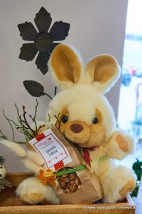 Präsent aus Stoff-Hasen mit Schokofrüchten dekoriert.