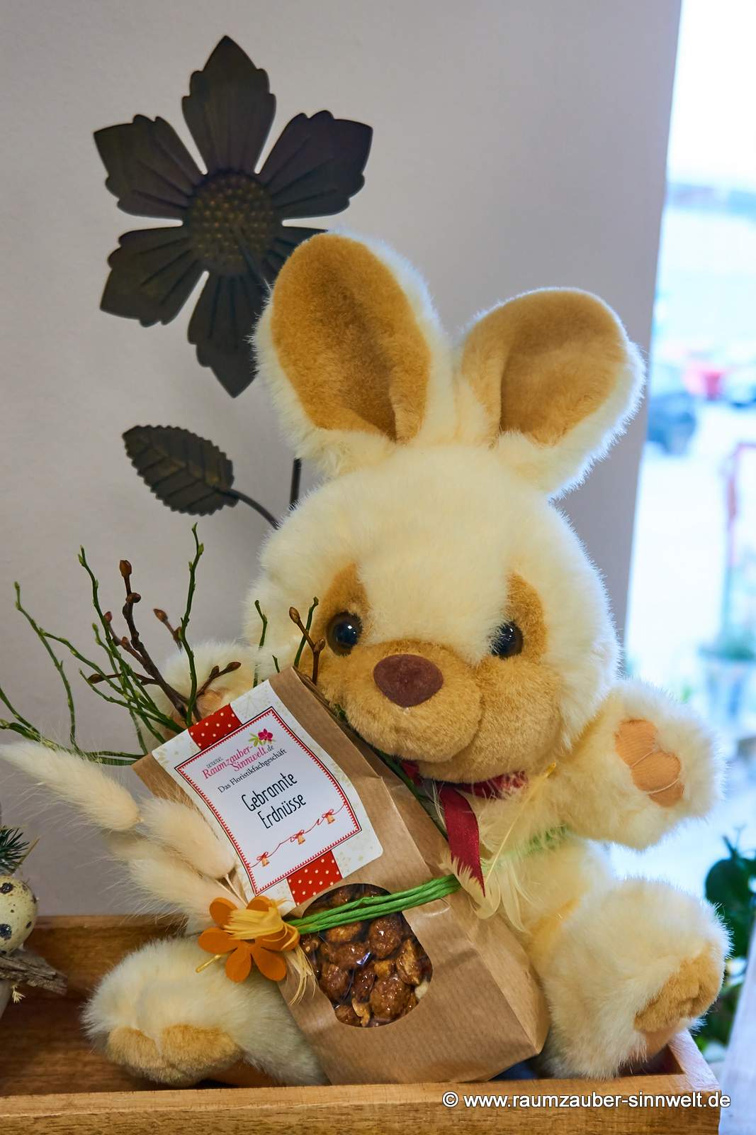 Präsent aus Stoff-Hasen mit Schokofrüchten dekoriert.