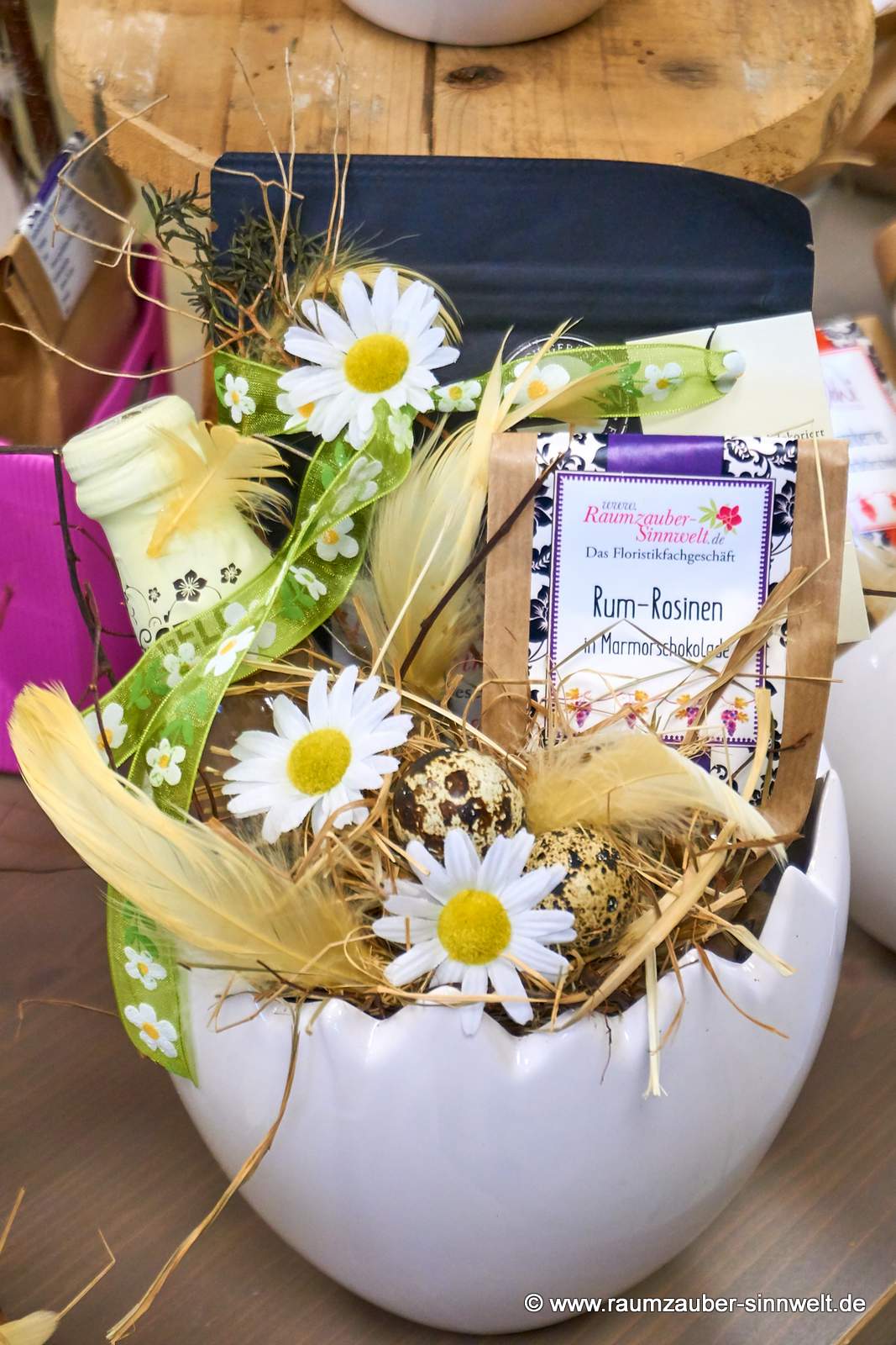 Präsent aus Likör "Scharfes Gelb", Schokofrüchten und Kaffee aus sächsischer Kaffee-Manufaktur in Kübel Cosmo von Tiziano österlich dekoriert