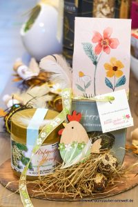 Präsent aus naturbelassenem Tee vom Grätz-Verlag und Neuseenland-Honig mit Dekohuhn österlich dekoriert.