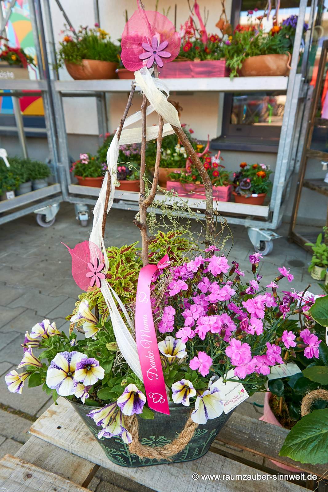 Einpflanzung dekoriert mit Nelken, Petunien und Spruchband