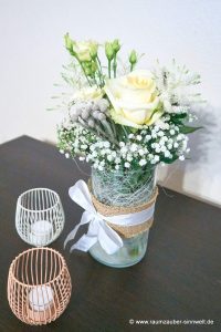 Tischdekoration aus Rosen, Astilben, Eustoma und Schleierkraut