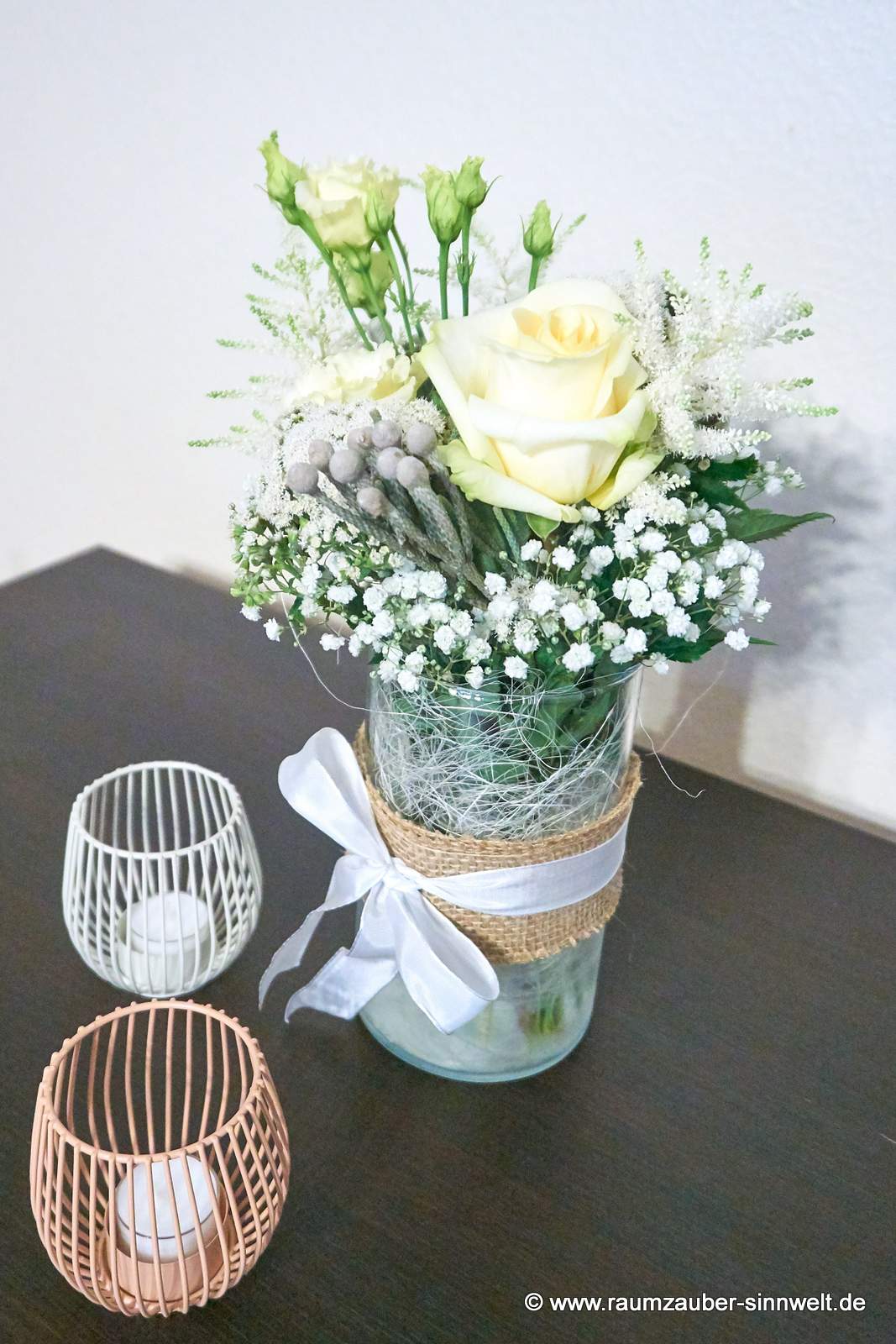 Tischdekoration aus Rosen, Astilben, Eustoma und Schleierkraut