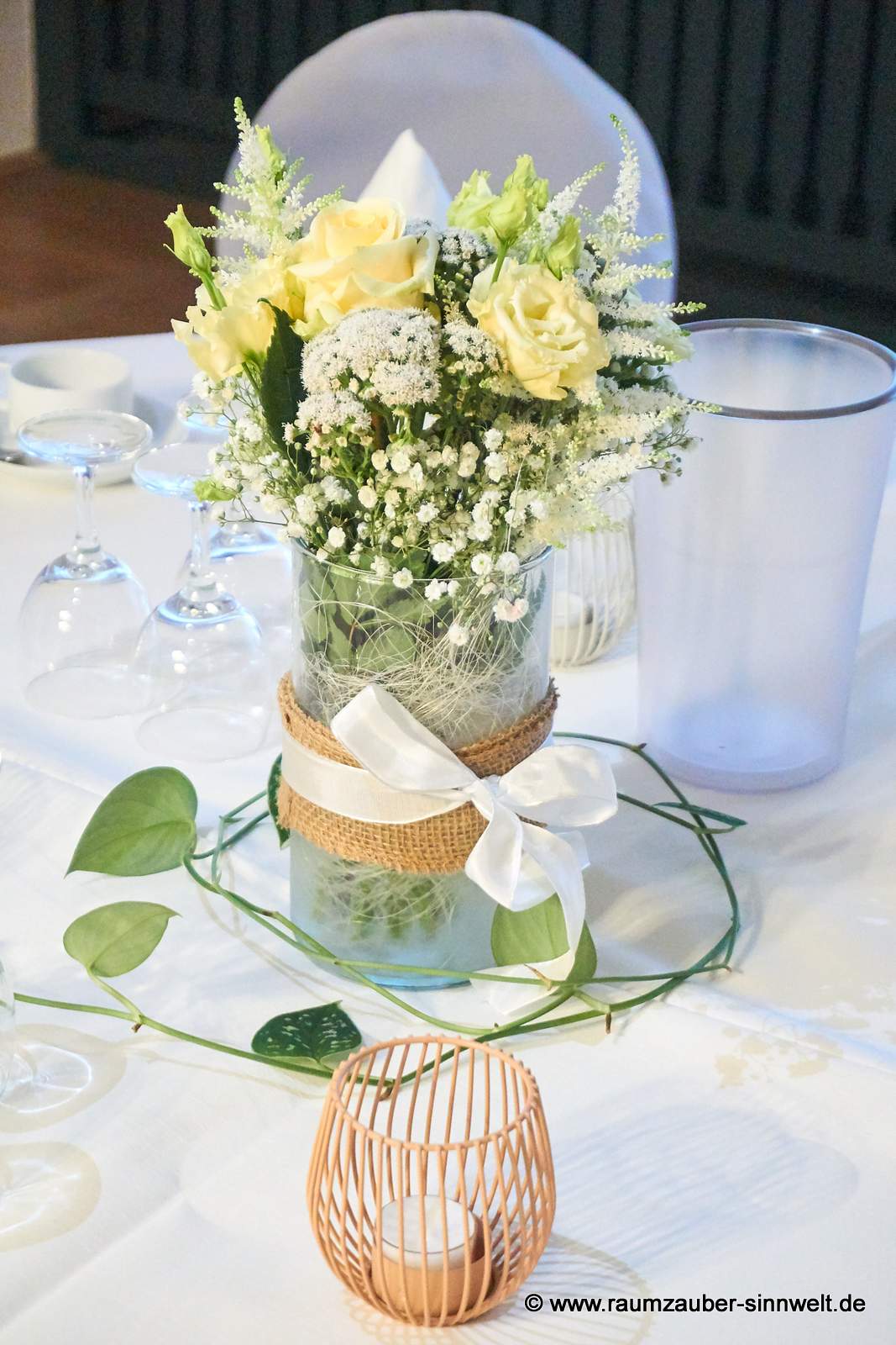 Tischdekoration aus Rosen, Astilben, Eustoma und Schleierkraut