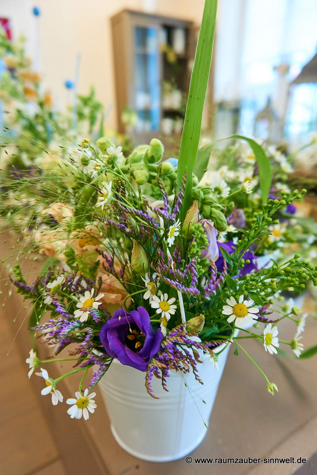 Tischdekoration aus Kamille, Eustoma, Limonium und Löwenmaul