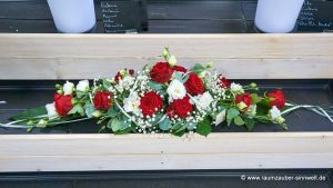 Tischschmuck aus Rosen, Eustoma, Schleierkraut und Eukalyptus
