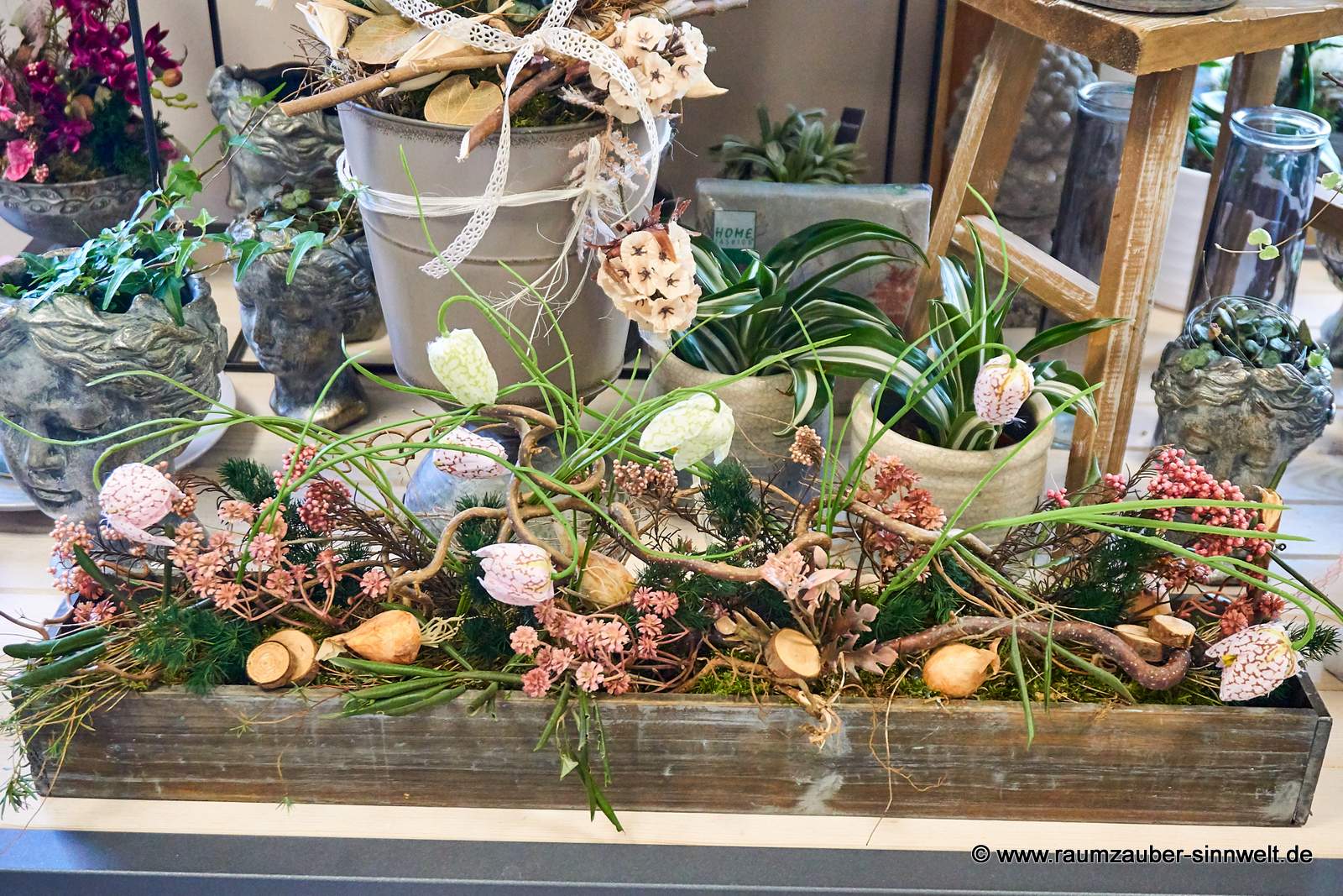Handgefertigte Seidenblumendekorationen mit Naturmaterialien im Holzgefäß