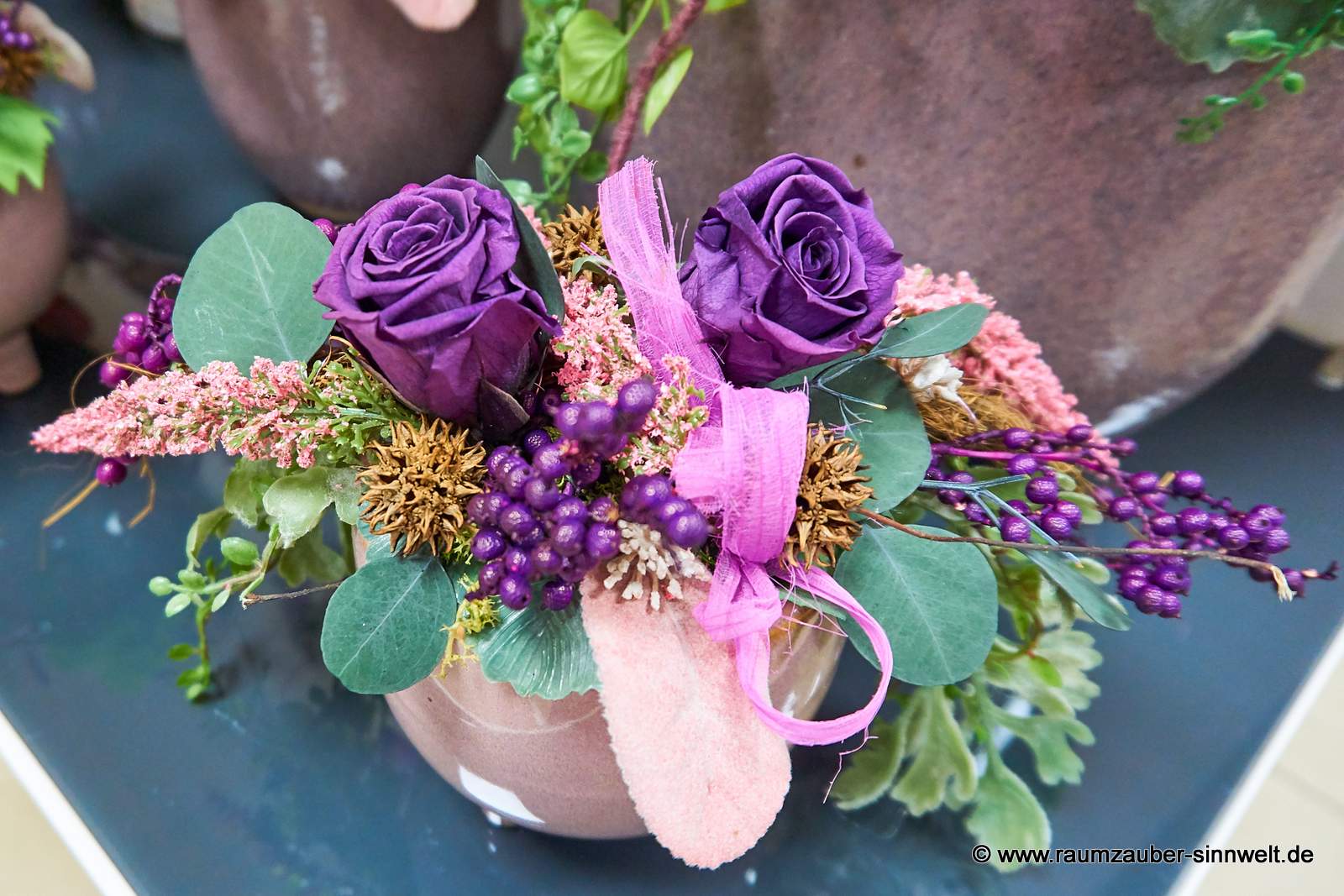 Handgefertigtes Gesteck aus Seidenblumen, Naturmaterialien und gefriergetrockneten Rosen als Praxisdekoration