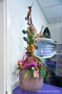 Handgefertigtes Gesteck aus Seidenblumen, Naturmaterialien und gefriergetrockneten Rosen als Praxisdekoration
