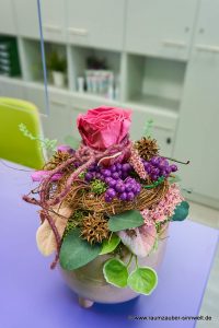 Handgefertigtes Gesteck aus Seidenblumen, Naturmaterialien und gefriergetrockneten Rosen als Praxisdekoration