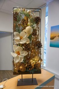 Weihnachtliche handgefertigte Seidenblumendekoration mit Naturmaterialien und LED-Lichterkette im Metallständer