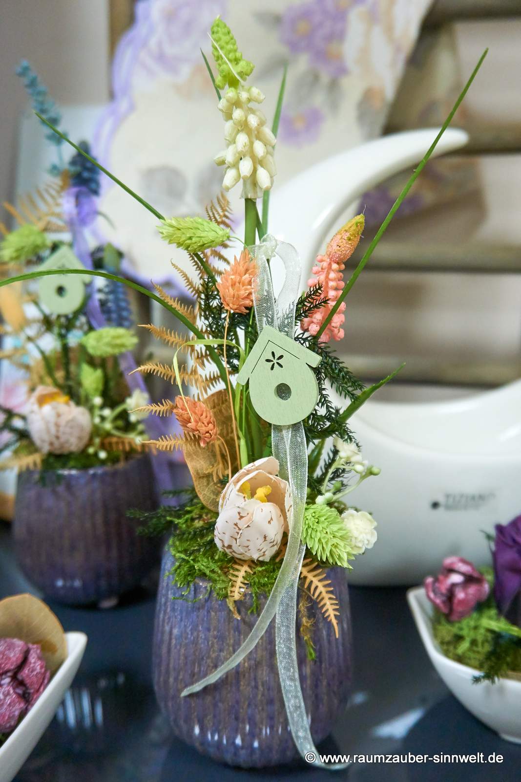 Handgefertigte Seidenblumendekoration mit Naturmaterialien im Keramikgefäß
